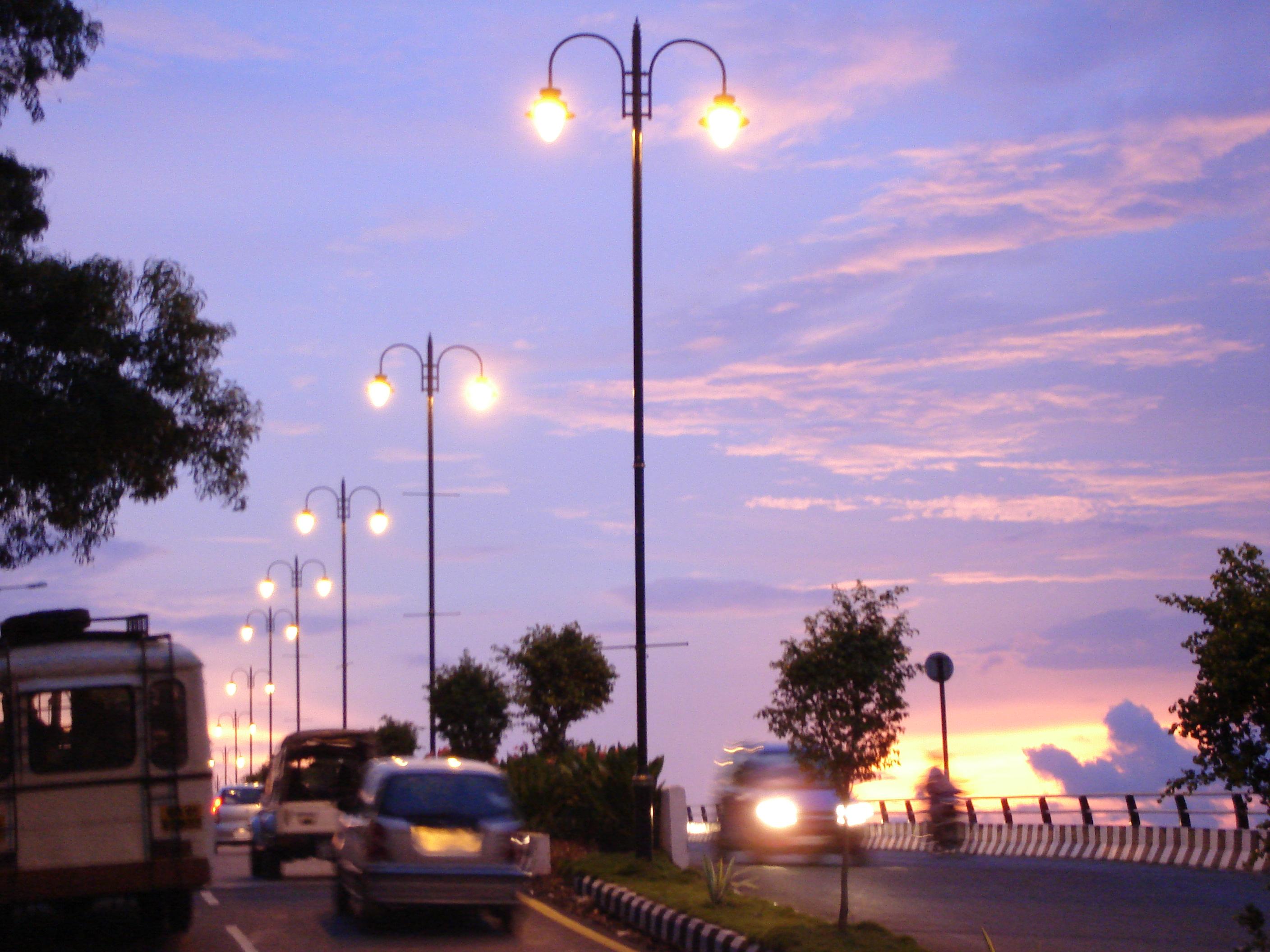 Cars driving along the road into Panjim at sunset, Goa